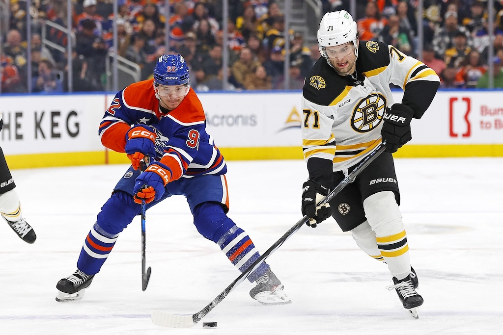 Dec 19, 2024; Edmonton, Alberta, CAN; Edmonton Oilers forward Vasily Podkolzin (92) tries to knock the puck away from Boston Bruins forward Oliver Wahlstrom (71) during the second period at Rogers Place. Mandatory Credit: Perry Nelson-Imagn Images