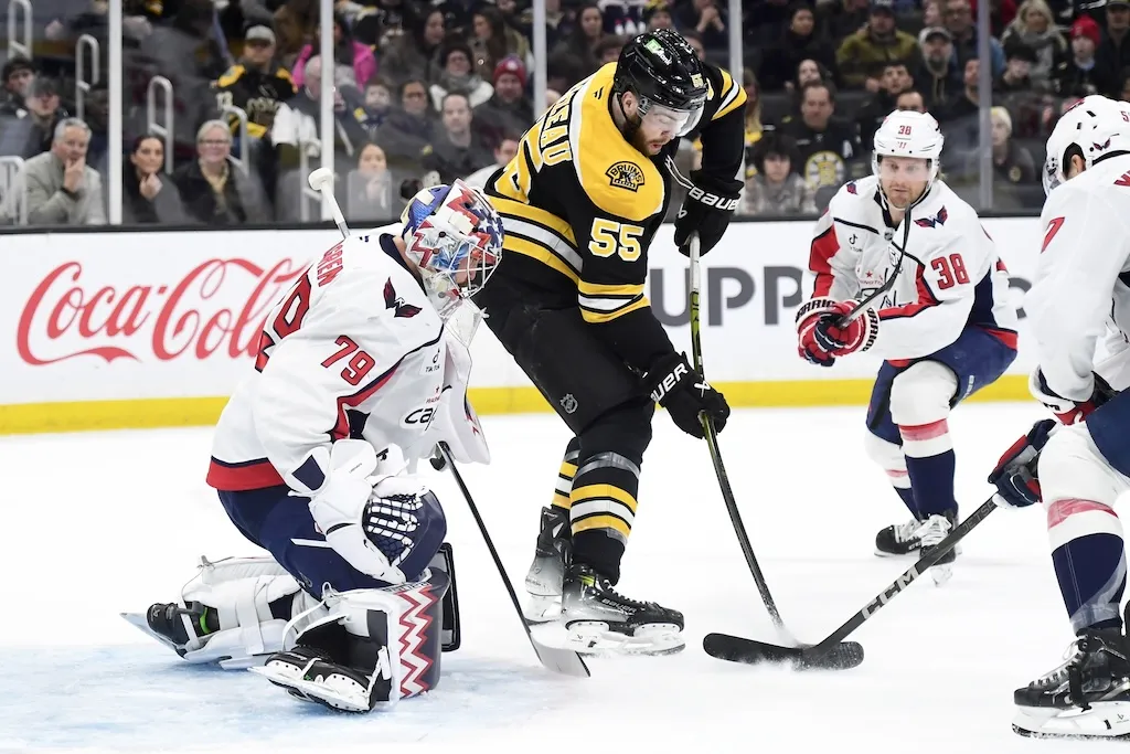 Dec 23, 2024; Boston, Massachusetts, USA; Boston Bruins right wing Justin Brazeau (55) backhands the puck past Washington Capitals goaltender Charlie Lindgren (79) during the first period at TD Garden. Mandatory Credit: Bob DeChiara-Imagn Images